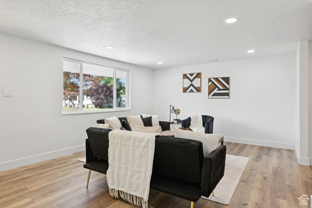 Dining space with a textured ceiling, recessed lighting, and light wood-style floors