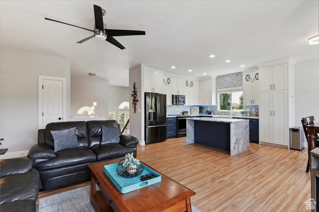 Living room featuring healthy amount of natural light, a ceiling fan, light wood-style floors, and recessed lighting