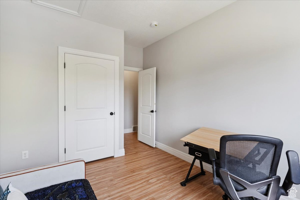 Office space with light wood-type flooring and baseboards