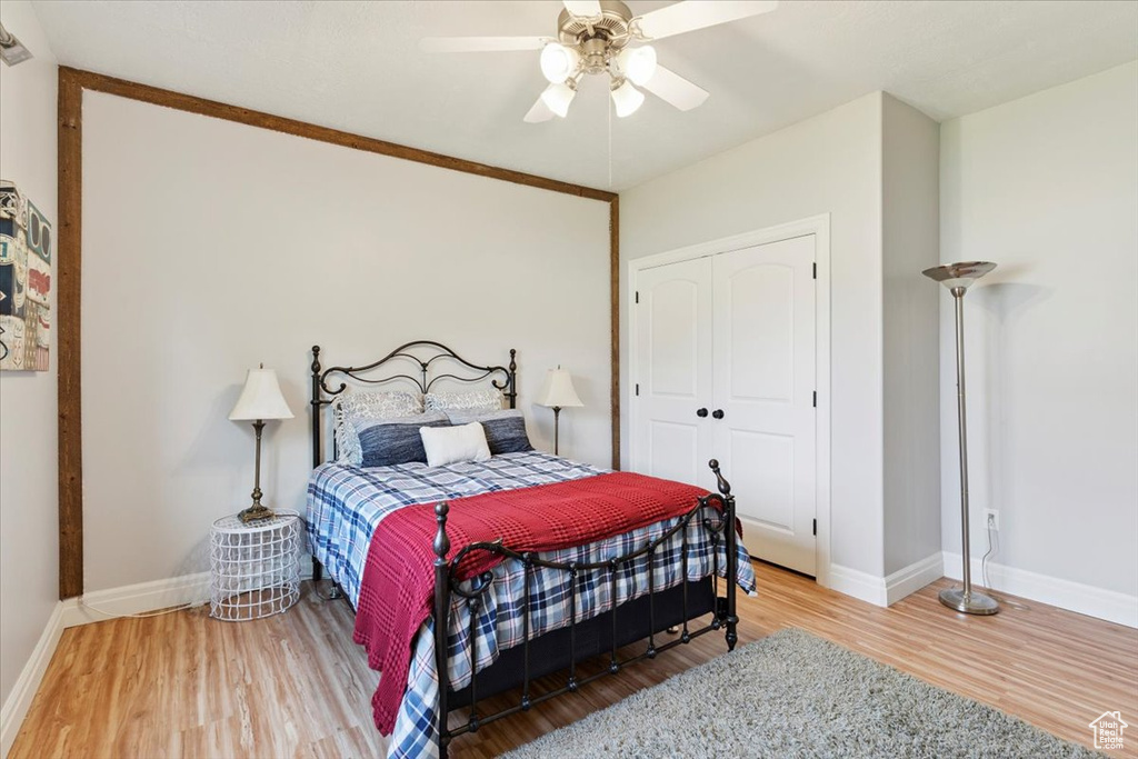 Bedroom with wood finished floors, a closet, and a ceiling fan