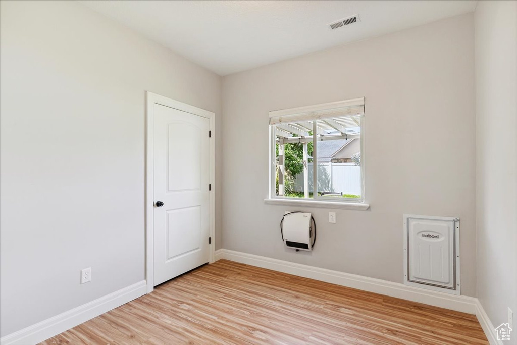 Spare room with light wood-style flooring and heating unit