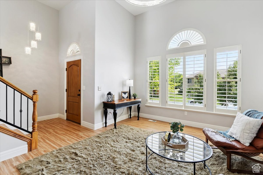 Entryway with a towering ceiling, wood finished floors, and stairway
