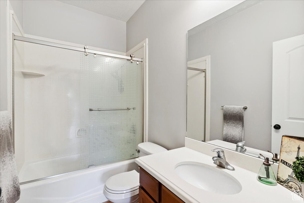 Bathroom featuring vanity and enclosed tub / shower combo