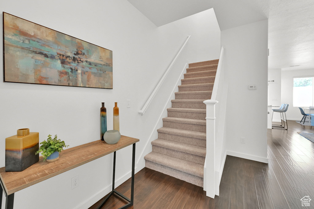 Staircase featuring wood finished floors and baseboards