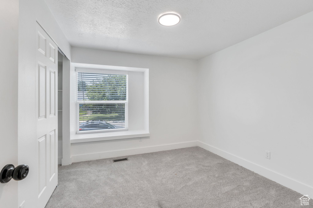 Unfurnished room featuring carpet floors and a textured ceiling