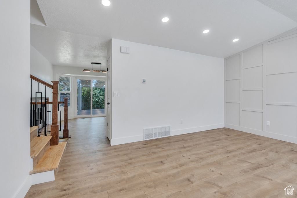 Unfurnished room featuring stairs, light wood-style flooring, recessed lighting, and built in features