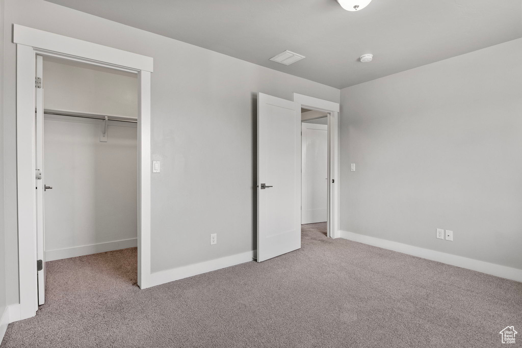 Unfurnished bedroom featuring carpet and a closet