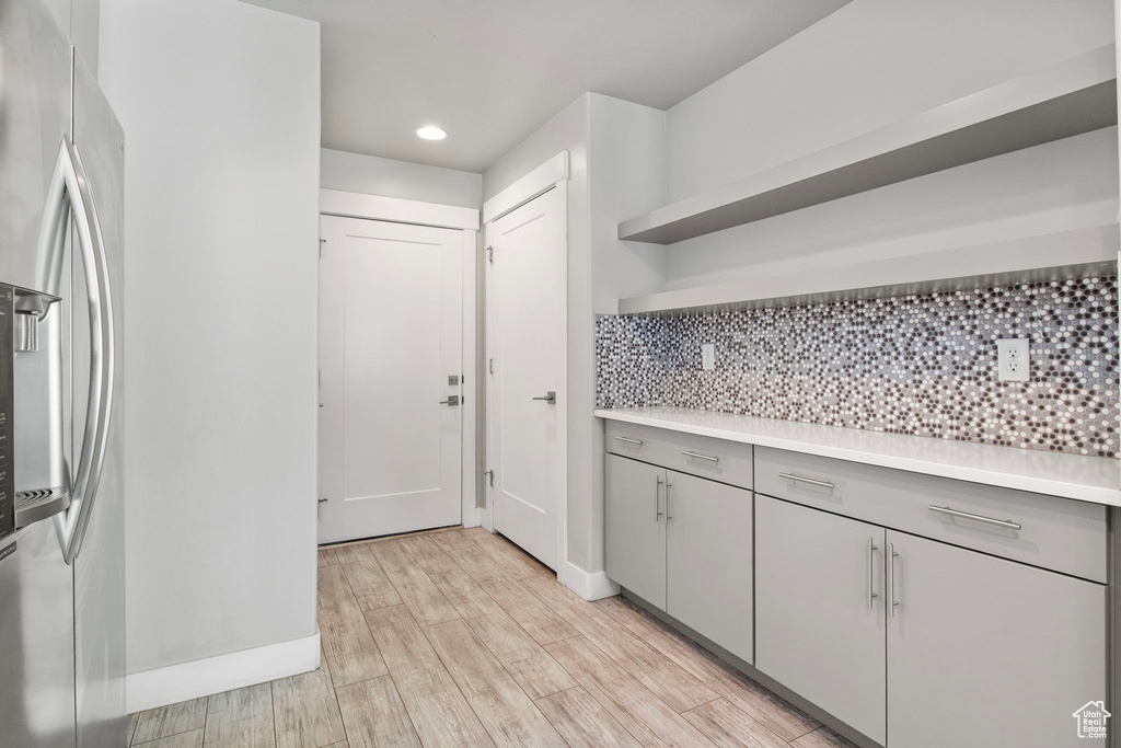 Kitchen with open shelves, gray cabinets, light countertops, decorative backsplash, and recessed lighting