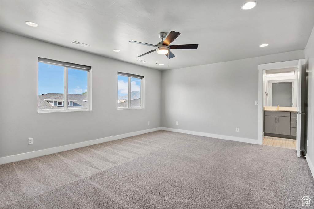 Carpeted empty room with a ceiling fan and recessed lighting