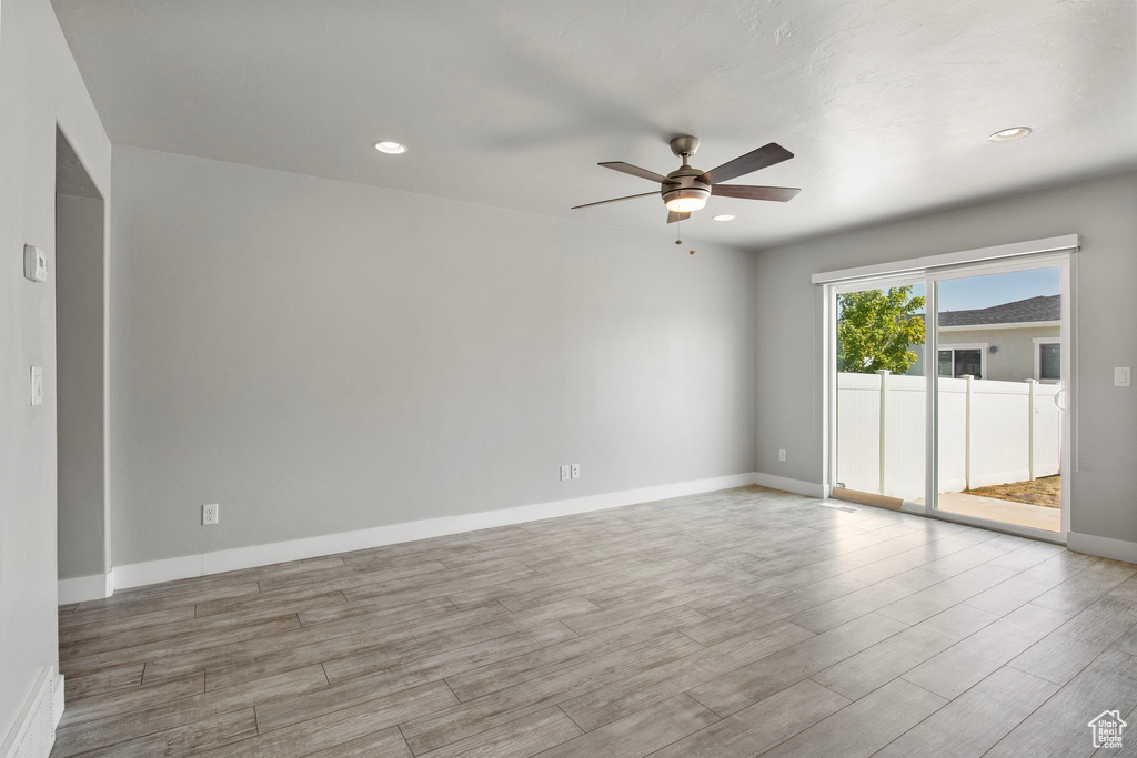 Empty room with ceiling fan, wood finished floors, and recessed lighting
