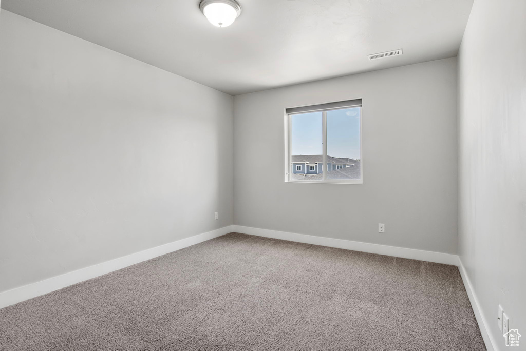 Carpeted empty room with baseboards