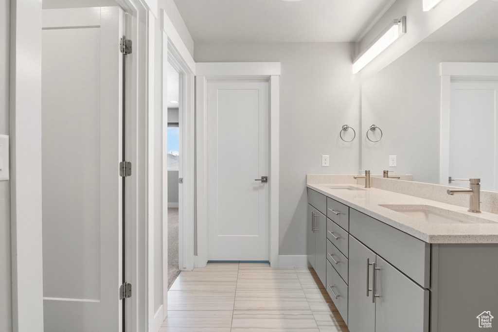 Bathroom featuring double vanity and baseboards