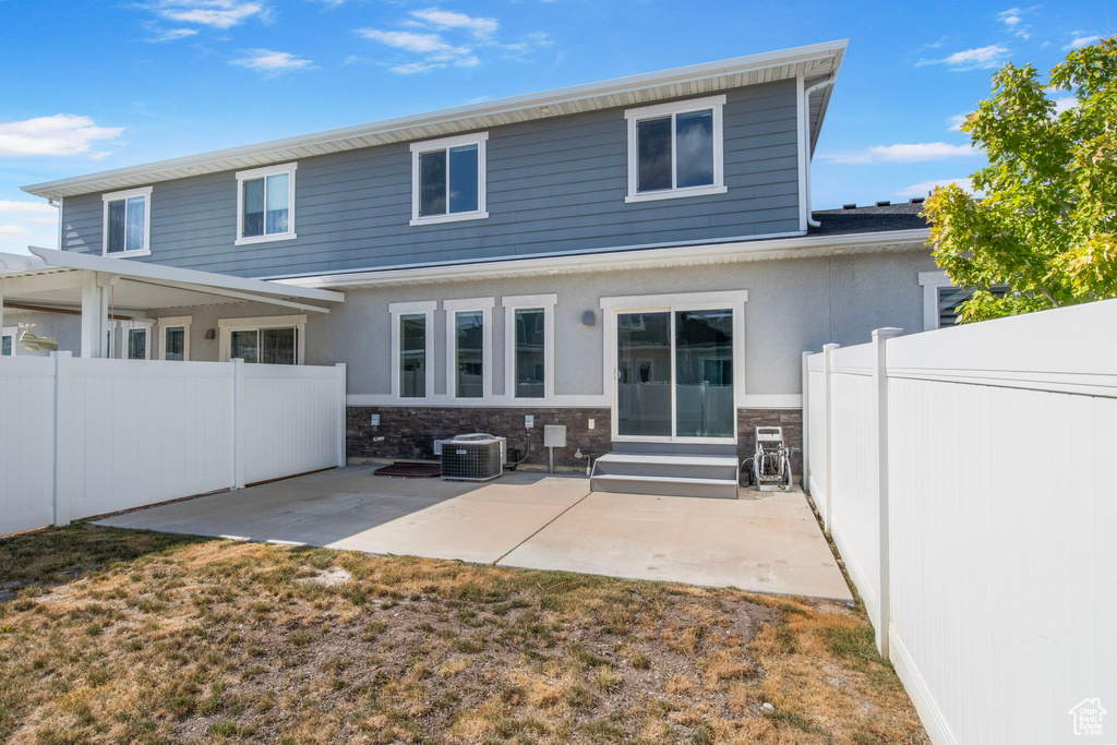 Back of property featuring entry steps, a patio area, stucco siding, and stone siding