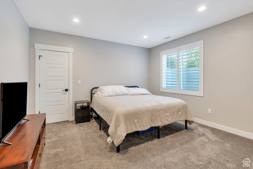 Carpeted bedroom with recessed lighting and baseboards