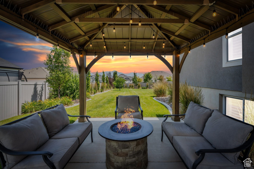 Patio terrace at dusk featuring an outdoor living space with a fire pit, a gazebo, and a patio