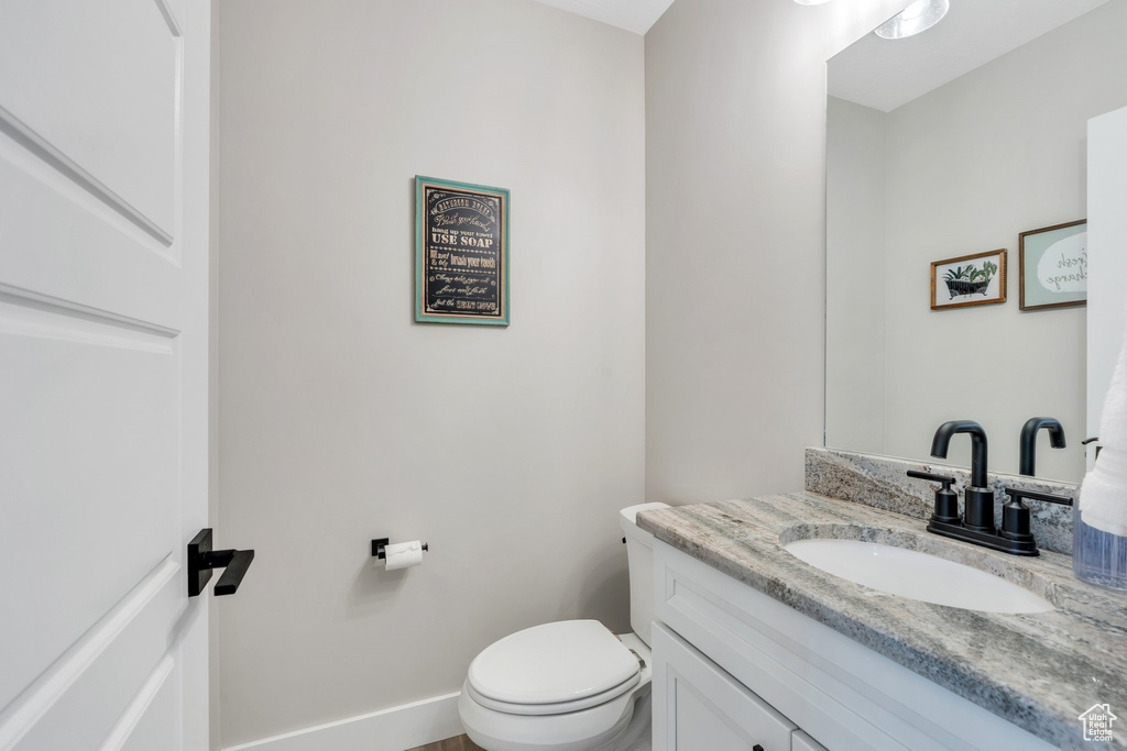 Half bathroom with vanity and toilet