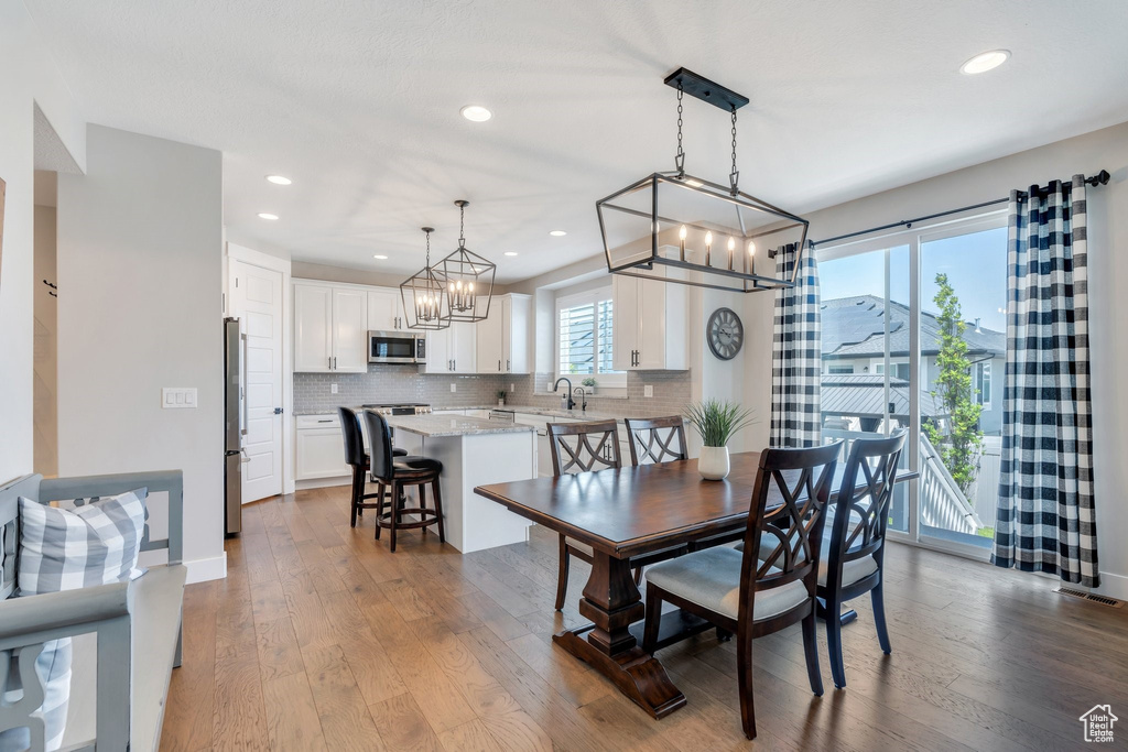Dining room featuring a chandelier, dark wood-type flooring, and recessed lighting