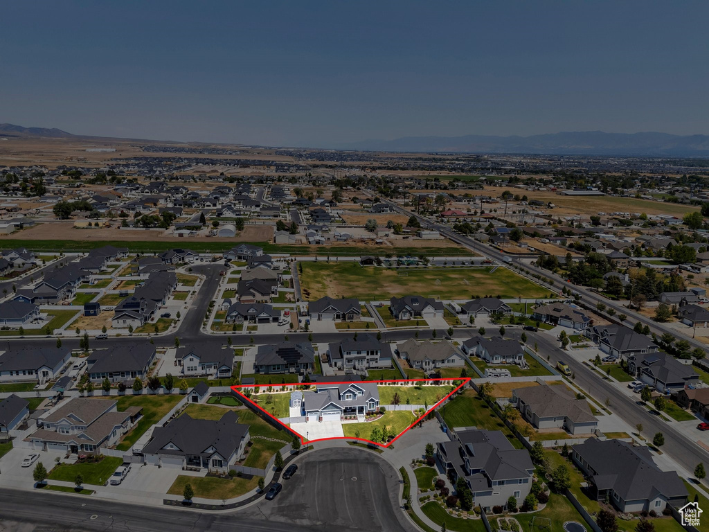 Aerial view of residential area featuring property boundaries highlighted and mountains