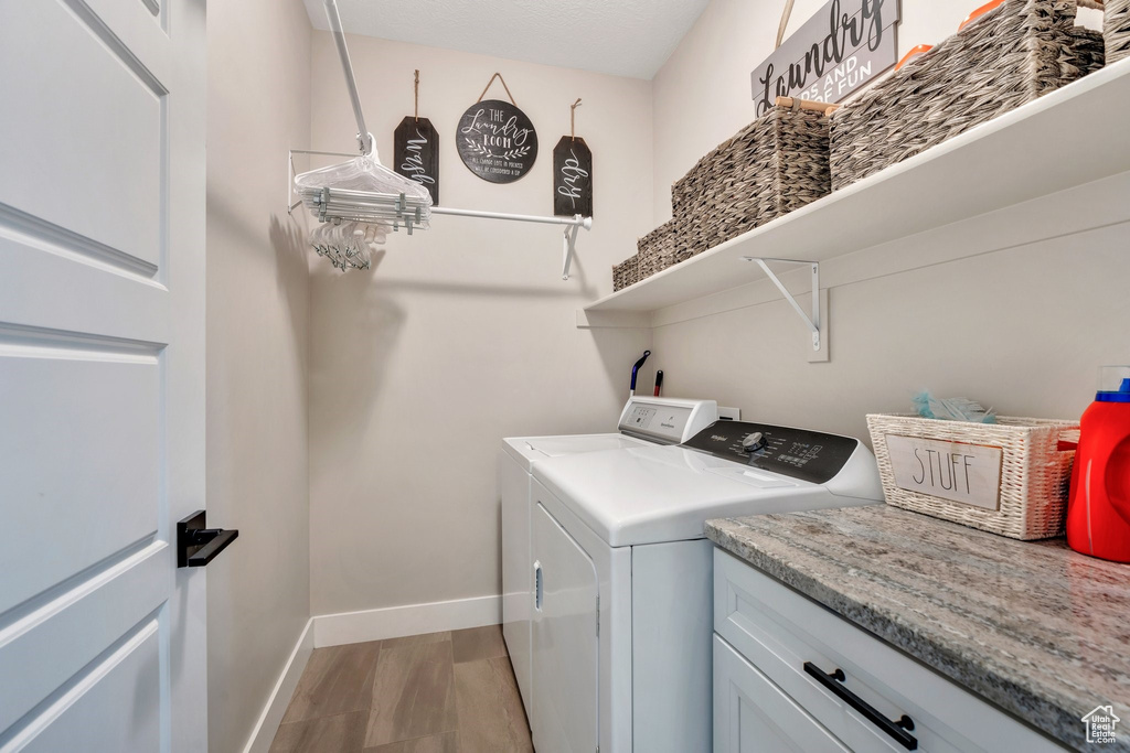 Washroom with washing machine and dryer and baseboards