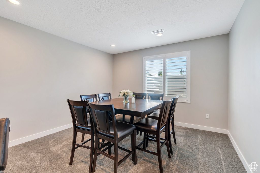 Carpeted dining area featuring recessed lighting and a textured ceiling