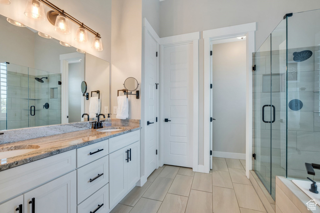 Full bathroom featuring a stall shower, double vanity, and tile patterned floors