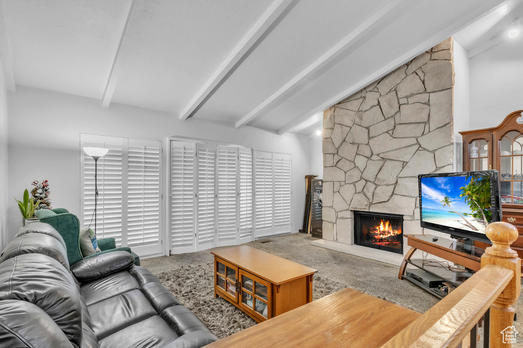 Carpeted living room with a stone fireplace