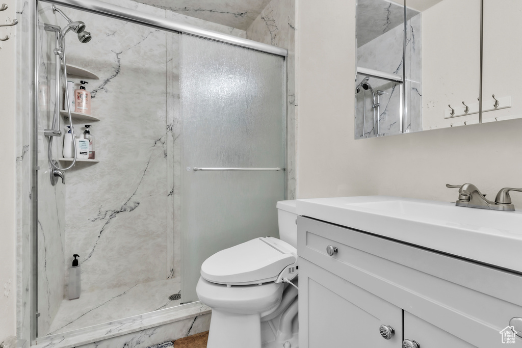 Bathroom with vanity and a marble finish shower