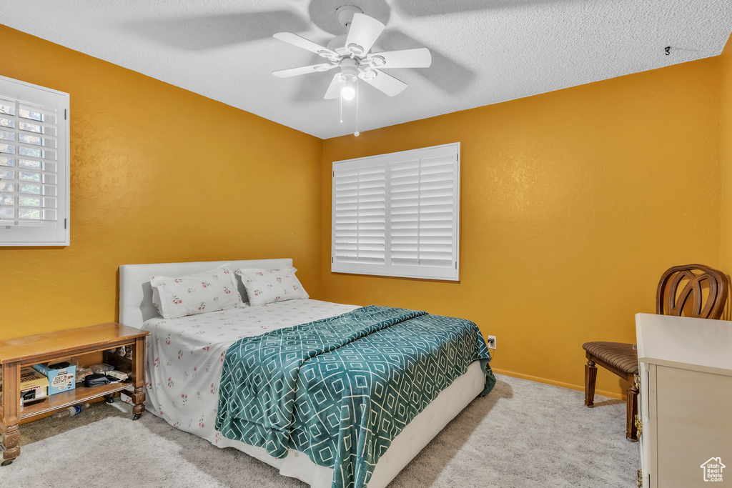 Carpeted bedroom featuring a ceiling fan