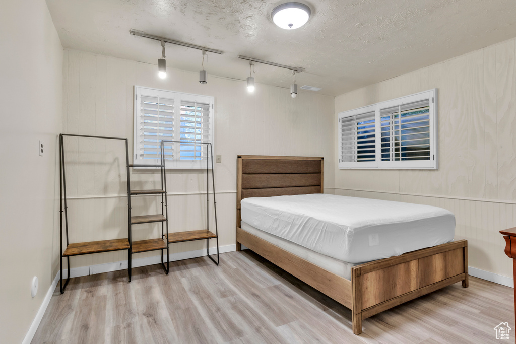 Bedroom featuring wood finished floors and track lighting