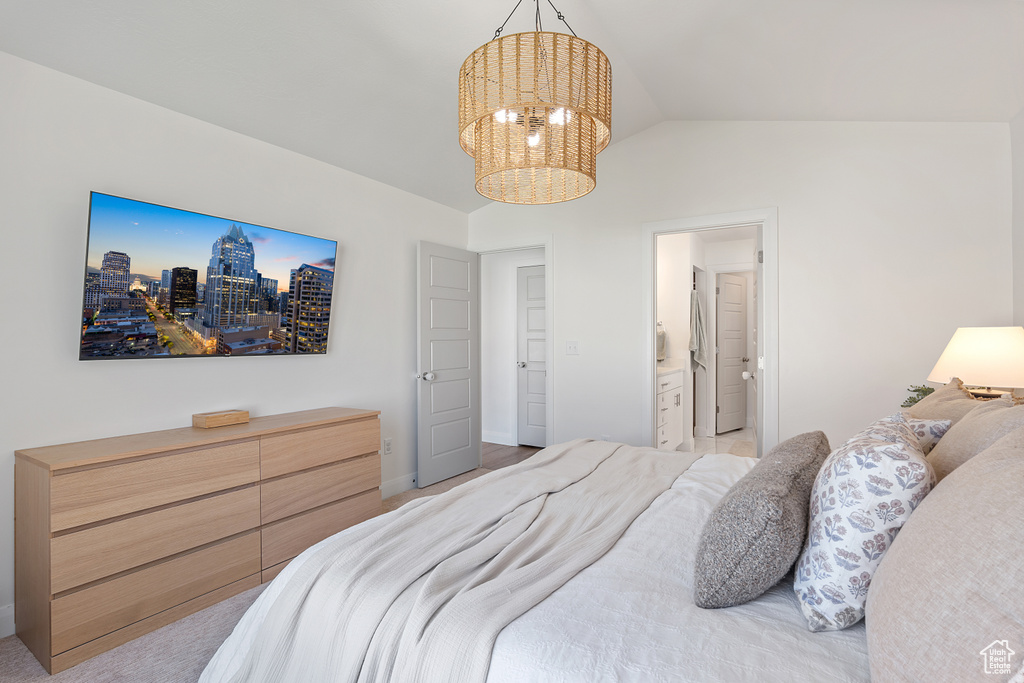 Bedroom featuring a chandelier, vaulted ceiling, and connected bathroom
