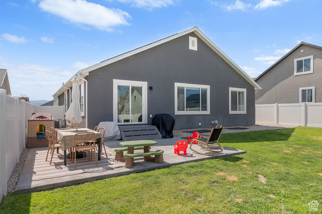 Rear view of property with a fenced backyard, a patio, and stucco siding