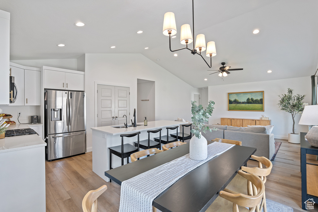 Dining area featuring vaulted ceiling, a ceiling fan, recessed lighting, and light wood finished floors