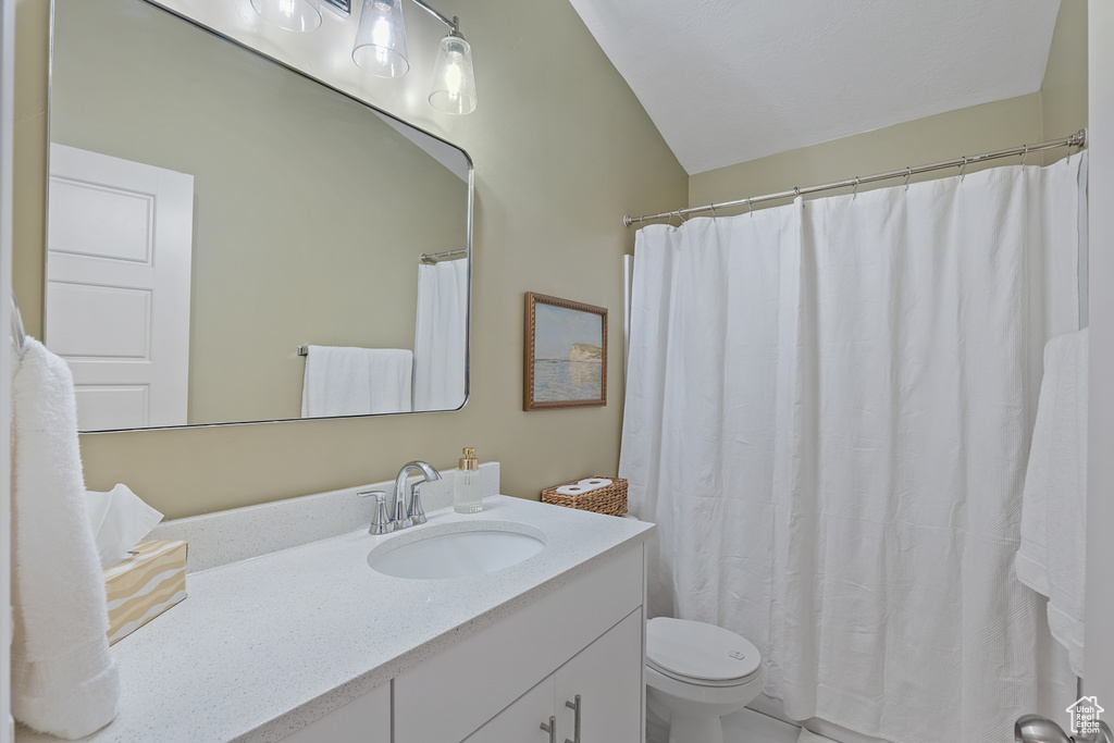 Bathroom with vanity, vaulted ceiling, and curtained shower