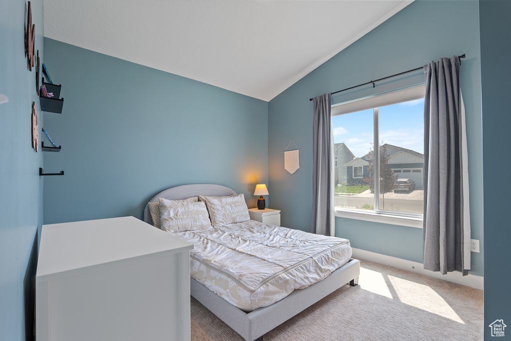 Carpeted bedroom featuring vaulted ceiling