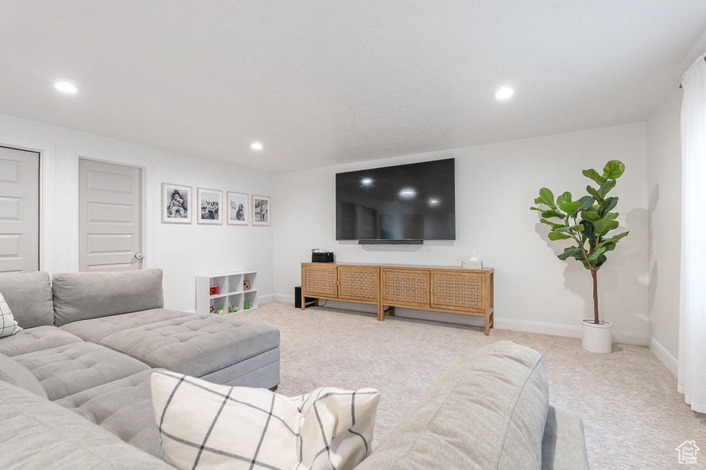 Living area with light carpet and recessed lighting