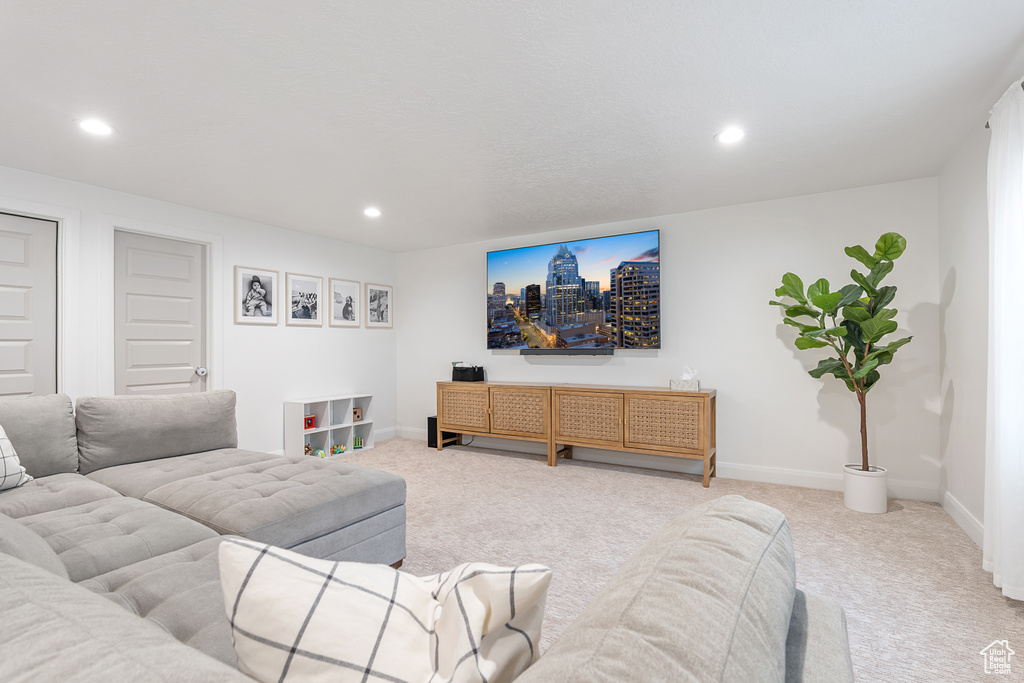 Living area with light colored carpet and recessed lighting