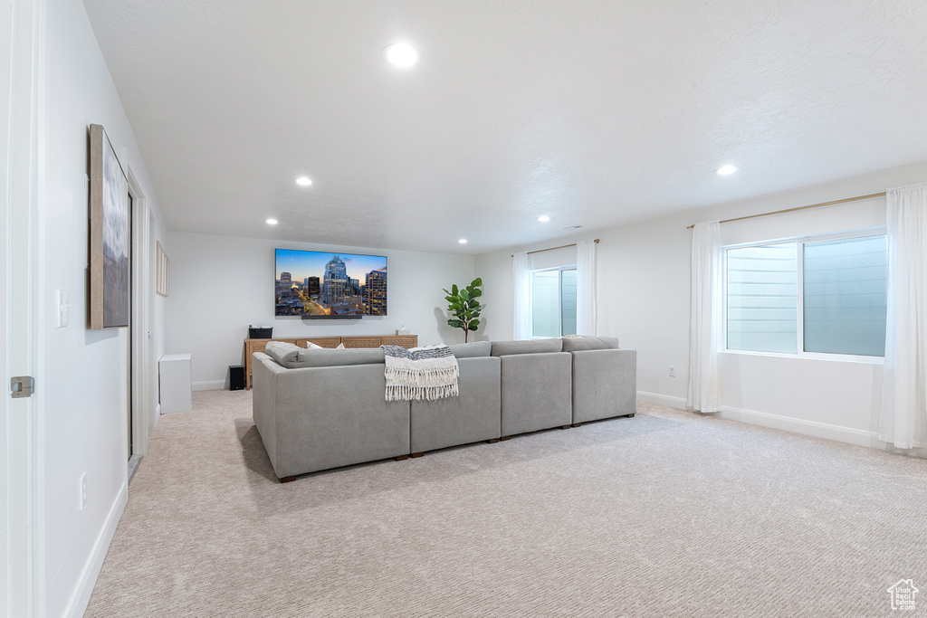 Living room with light colored carpet and recessed lighting