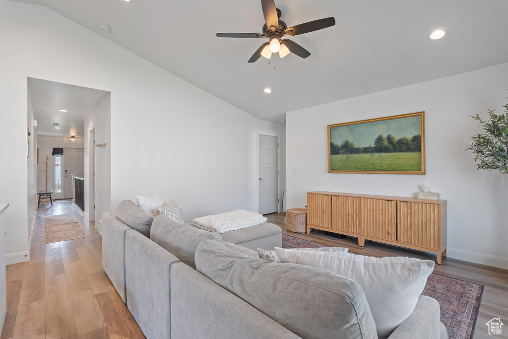 Living room featuring a ceiling fan, recessed lighting, light wood-style flooring, and high vaulted ceiling