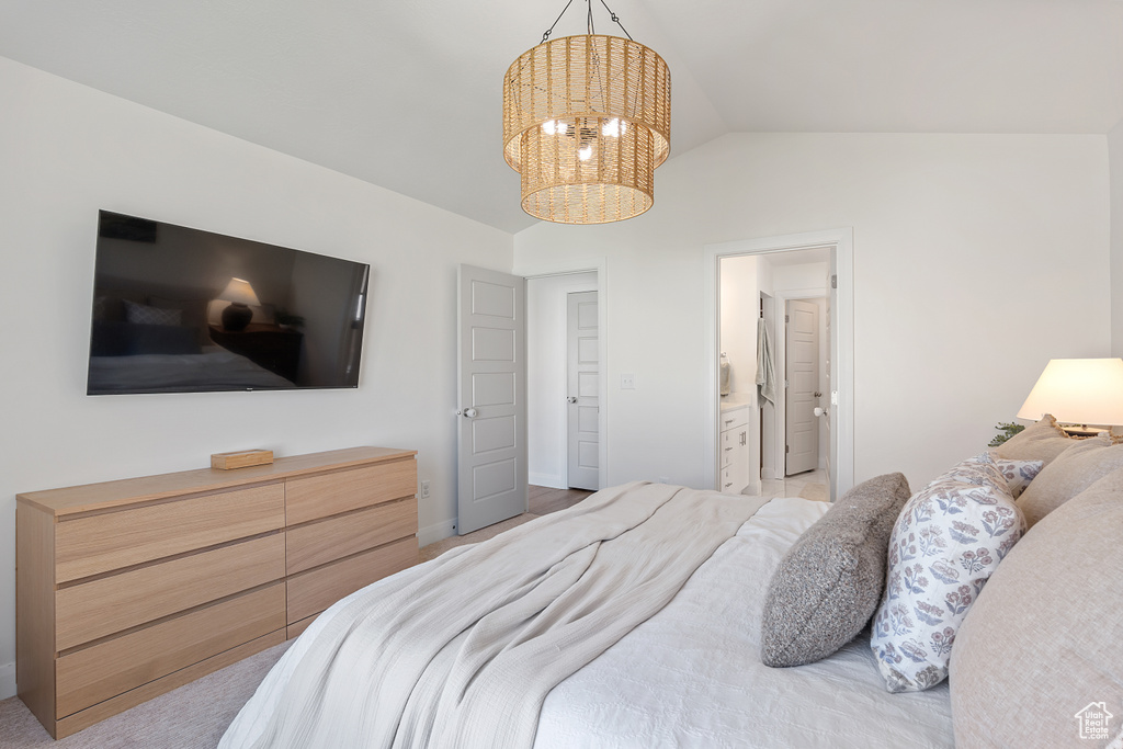Bedroom with a chandelier, lofted ceiling, and ensuite bath