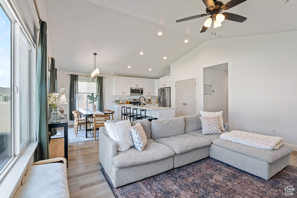 Living area featuring recessed lighting, vaulted ceiling, a ceiling fan, and light wood finished floors