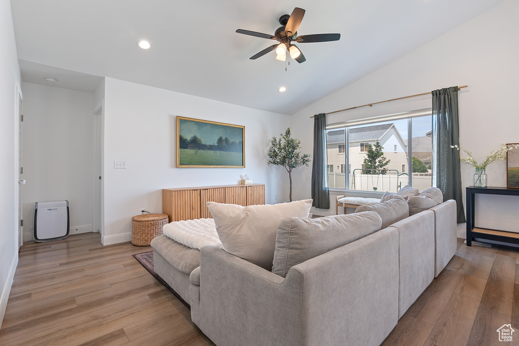 Living room with ceiling fan, light wood-style floors, lofted ceiling, and recessed lighting