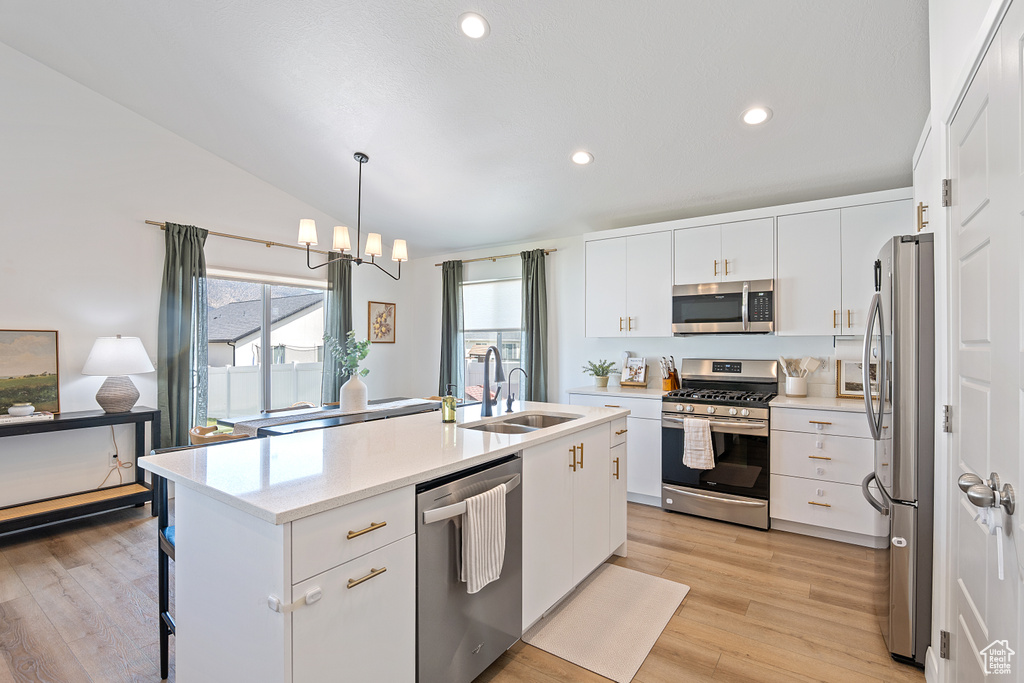 Kitchen featuring appliances with stainless steel finishes, light wood-style floors, lofted ceiling, white cabinetry, and recessed lighting
