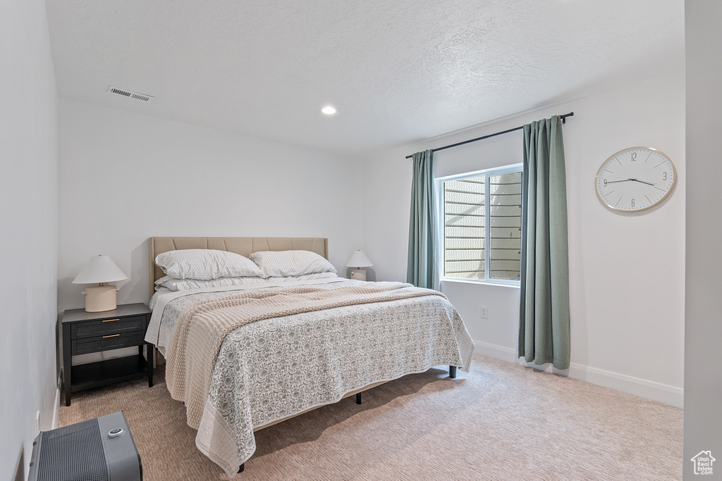 Carpeted bedroom featuring recessed lighting and a textured ceiling