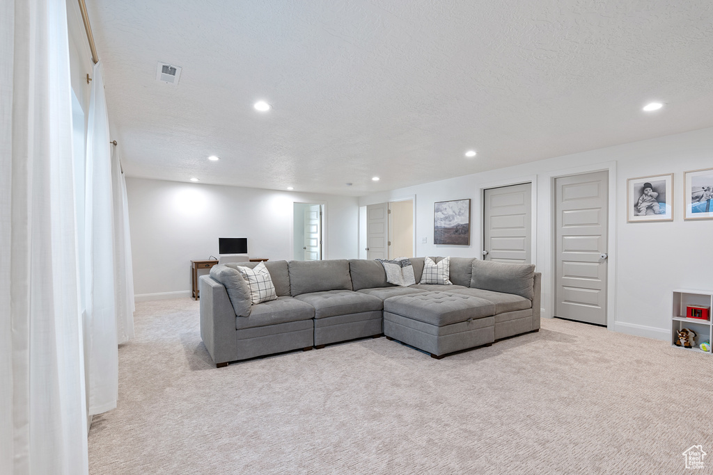 Carpeted living room featuring recessed lighting and baseboards