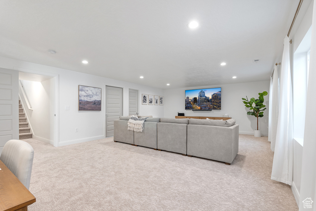 Living room featuring recessed lighting, light colored carpet, and stairway