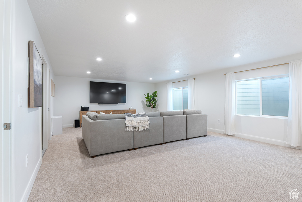 Living area featuring light colored carpet and recessed lighting