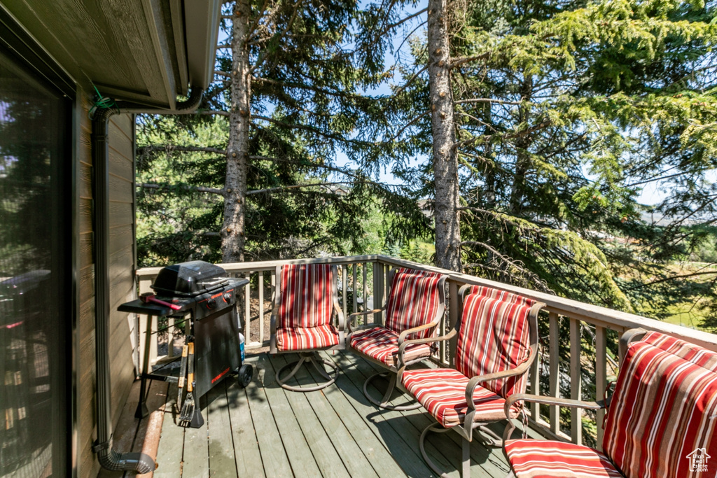 Deck featuring area for grilling and view of scattered trees