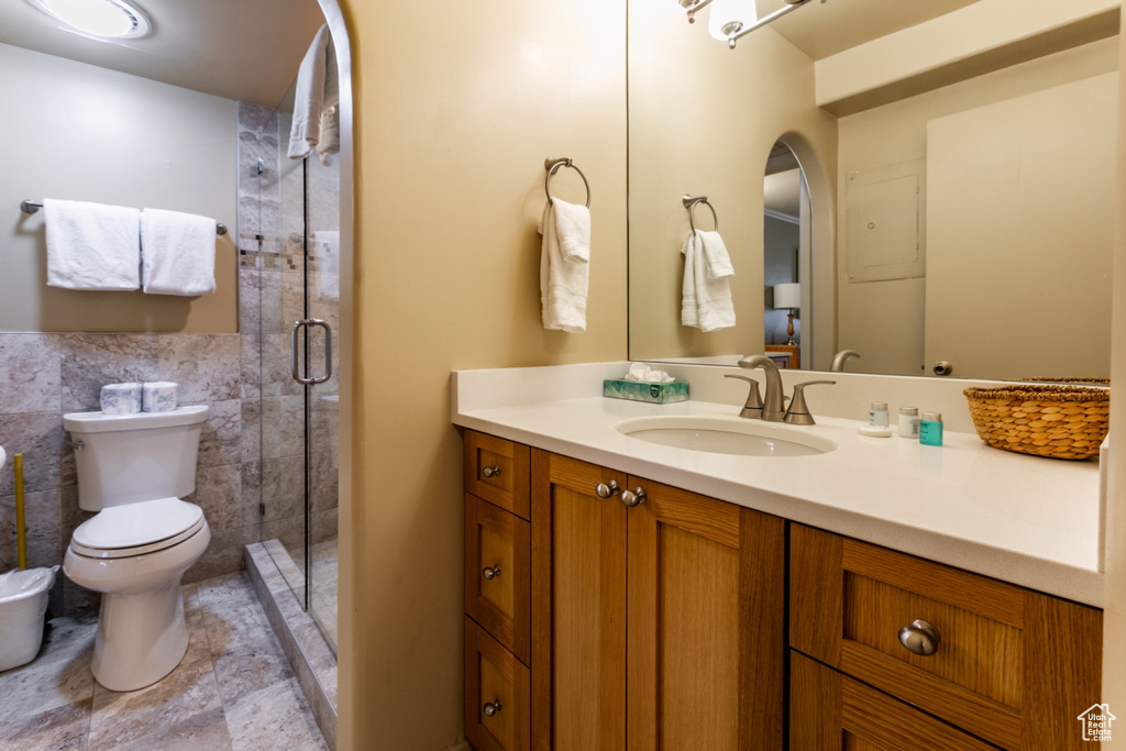 Full bathroom with vanity, a shower stall, a bidet, and tile walls