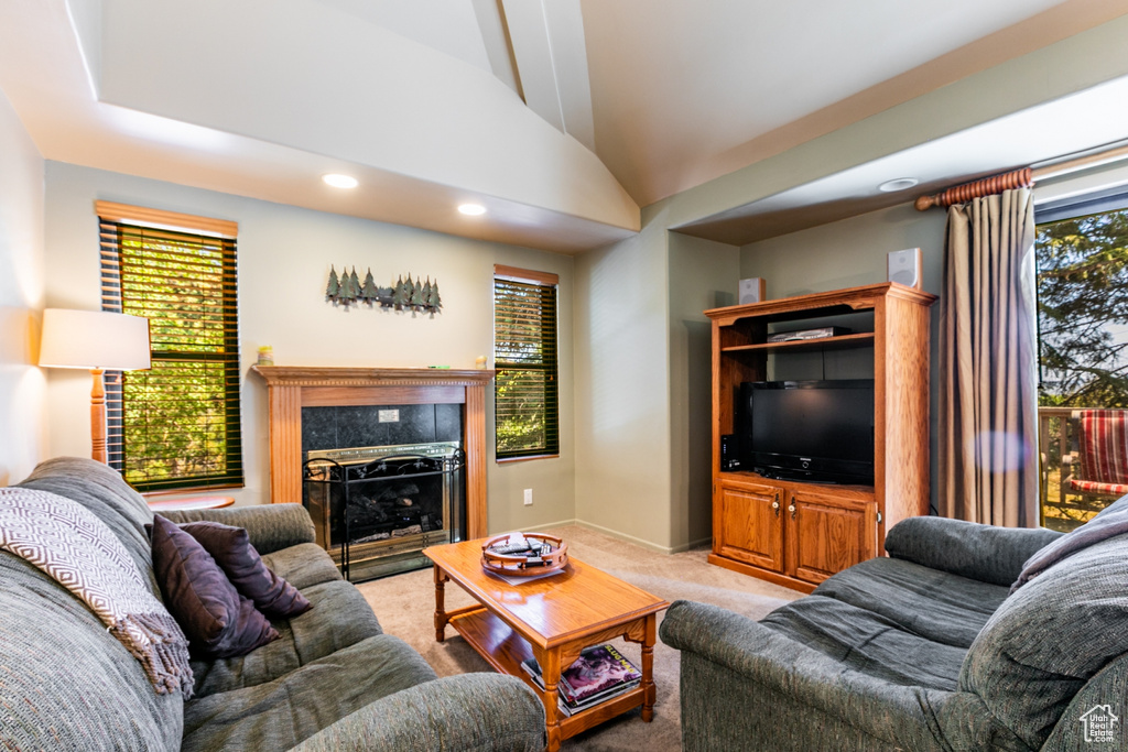Living room featuring light carpet, vaulted ceiling, recessed lighting, and a fireplace