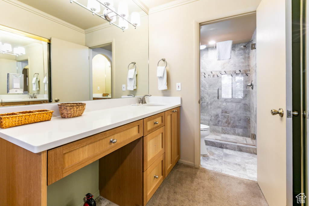 Bathroom with ornamental molding, vanity, and a shower stall